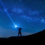 A level results day guidance for parents represented by someone holding torch searching the sky